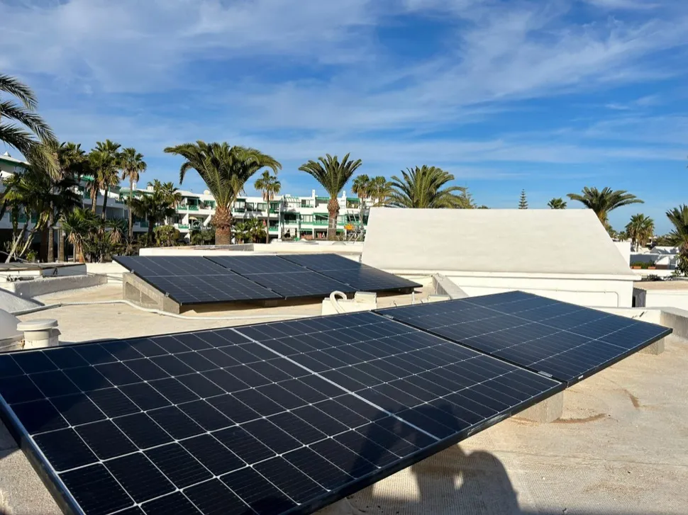 Paneles solares junto a palmeras en una vivienda de Lanzarote